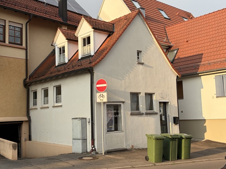 Das Milchhäusle von der Straße aus: schmales Haus mit Satteldach und zwei Gauben
