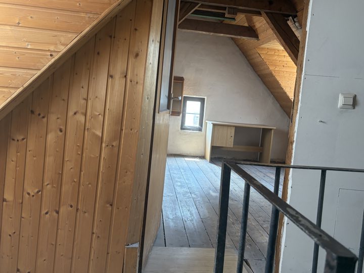 Blick über den Flur in den künftigen Wohnraum mit Dielenboden