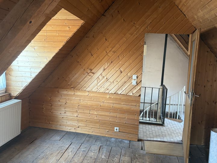 Holzvertäfelte Wände und Tür zum Treppenbereich mit der Wendeltreppe