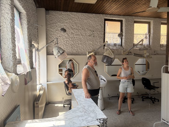 Der ehemalige Salon: großer Raum mit Fensterfront und Bedienplätzen